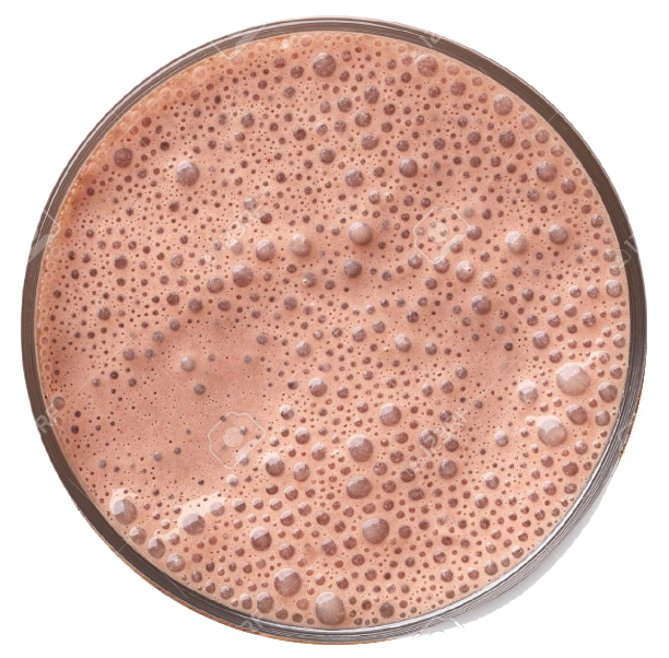 Close-up of a glass filled with a frothy pinkish-brown mushroom nootropic beverage on a white background